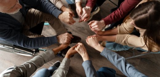 Diverse group of people linking hands